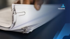 a process server flicking through a pile of legal documents held together with a paperclip